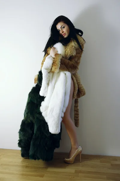 Young girl with several natural fur coats — Stock Photo, Image