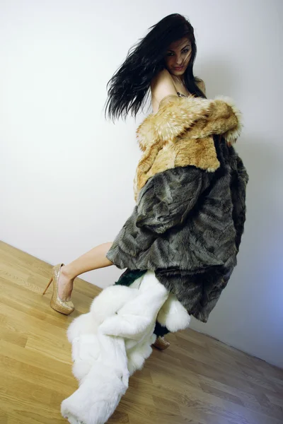 Young girl with several natural fur coats — Stock Photo, Image