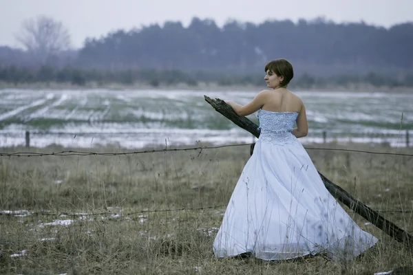 Одинокая девушка на зимнем поле — стоковое фото