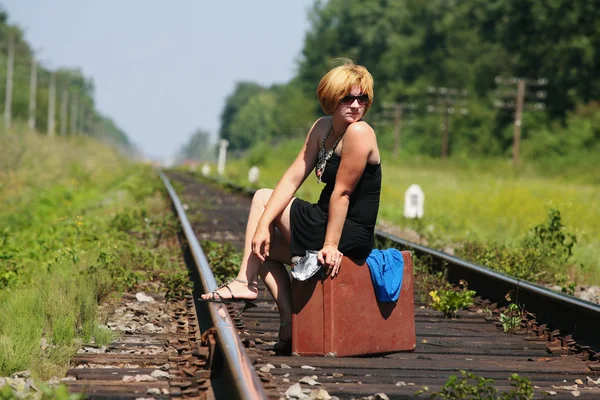 Meisje op het spoor van de spoorlijn met koffer — Stockfoto