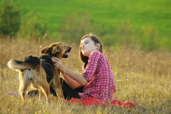 Menina brincando com seu cão no campo — Fotografia de Stock