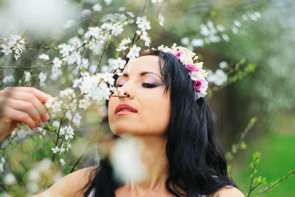Menina agradável relaxado perto de ramos flor — Fotografia de Stock