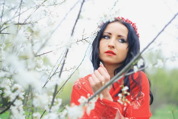 Chica agradable relajado cerca de ramas de flores —  Fotos de Stock