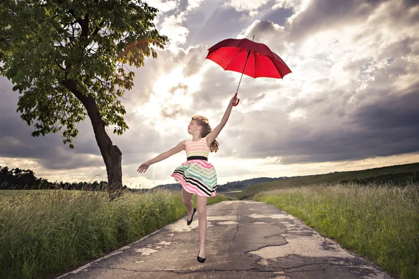 Jumping girl with umbrella — Stock Photo, Image