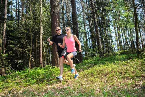 Nordic walking man och kvinna — Stockfoto