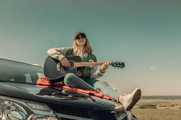 Kırsal Yolculukta Arabasının Kaputunda Gitar Çalan Genç Bir Kız — Stok fotoğraf