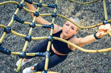young woman at physical activities or workout on a fitness path in the park