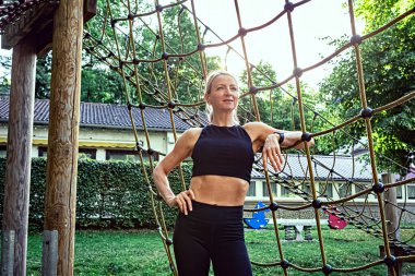 young woman at physical activities or workout on a fitness path in the park