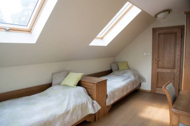 bedroom interior in light pastel tones and sloping roof