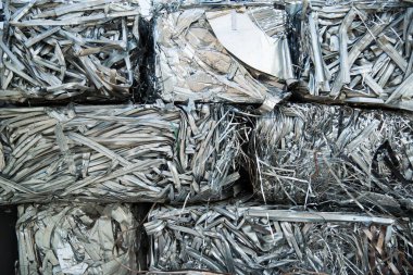 Geniş çaplı bir kazıcı metal geri dönüşüm alanında çelik bir kazıda çalışıyor. Endüstriyel metal geri dönüşümü - seçici odak, kopyalama alanı