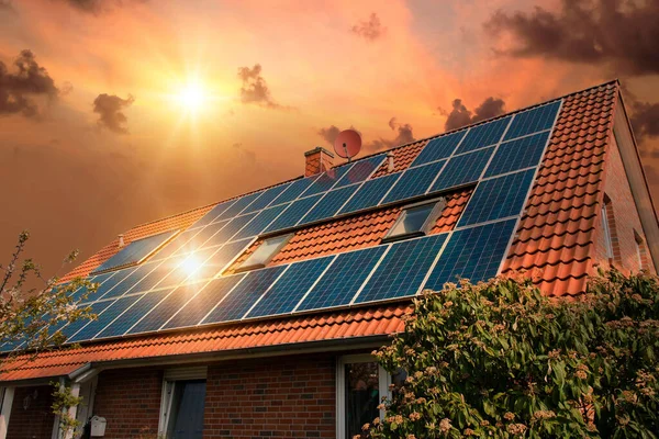 Güneş panellerinin fotoğraf kolajı, kırmızı çatıdaki fotovoltaikler ve batan güneşli güzel bir gökyüzü. Alternatif elektrik kaynağı. Sürdürülebilir kaynaklar kavramı