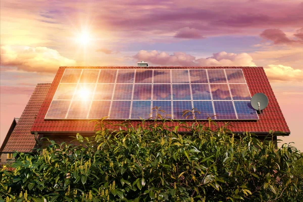 Güneş panellerinin fotoğraf kolajı, kırmızı çatıdaki fotovoltaikler ve batan güneşli güzel bir gökyüzü. Alternatif elektrik kaynağı. Sürdürülebilir kaynaklar kavramı