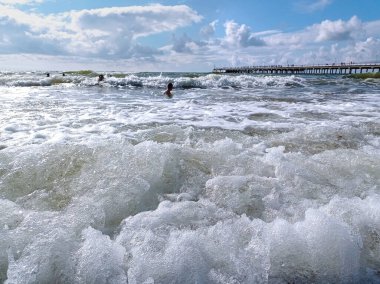 Baltic sea in summer time. Children swimming in the waves.