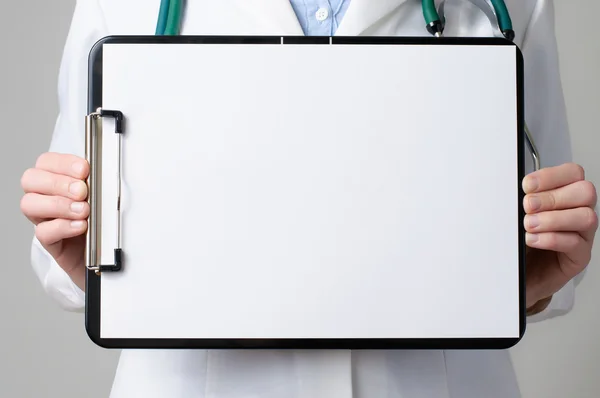 Doctor showing blank clipboard — Stock Photo, Image