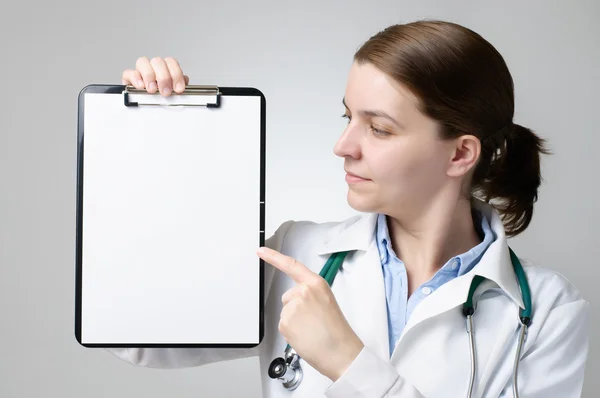 Doctor pointing at blank clipboard — Stock Photo, Image