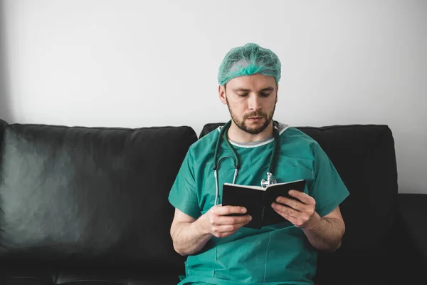 Doctor leyendo un libro en la sala de descanso —  Fotos de Stock