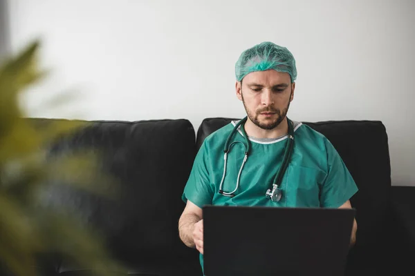 Doctor looking at laptop in the resting room — Stock Photo, Image