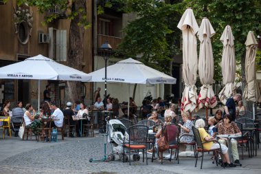 BELGRAD, SERBIA - 12 Haziran 2021: Belgrad şehir merkezinde kalabalık bir kafe terasında oturan yaşlı kadınlar, torunlarıyla birlikte büyükanneleri seçici bir bulanıklık.