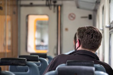 BELGRAD, SERBIA - 1 Mayıs 2021: bir EMU içinde seyahat üst düzey bir adam başkanı eski bir banliyö tren, Avrupa tarzı, kentsel bir çevrede seyahat