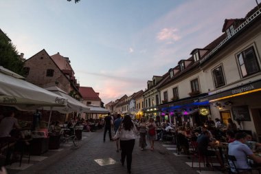 ZAGREB, CROATIA - 19 Haziran 2021: Akşamları kalabalık restoranlar, kafeler, barlar ve yemek tesislerinin önünden geçen kalabalık Ulica Ivana Tkalcica caddesi üzerinde seçici bir odak noktası.