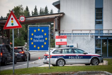 KRAINBERG, AUSTRIA - 13 Eylül 2021: Avusturya Bundespolizei polis arabası Coronavirus Covid 19 krizi sırasında Avusturya 'nın Sloven sınır kapısında AB sınır tabelasıyla insanları kontrol ediyor.