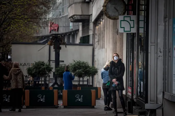 Belgrade Serbia エイプリル社2021年3月 コロナウイルスCovid 19危機の顔マスク保護装置を装着した薬局の前で待機中の若い女性 — ストック写真