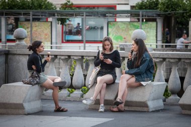 LJUBLJANA, SLOVENIA - 15 Haziran 2021: Üç kız, genç kadın, yetişkin, Slovenler, yazın Ljubljana şehir merkezinde oturmuş dondurma yiyorlar. Ljubljana Slovenya 'nın başkenti.