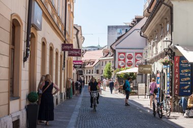 LJUBLJANA, SLOVENIA - 14 Haziran 2021: Öğleden sonra Trubarjeva Ceasa caddesinden geçen bisiklet ve yakınlardaki dükkanlar. Trubarjeva, Ljubljana 'nın ana yaya sokağıdır..