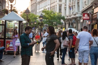BELGRAD, SERBIA - 20 Temmuz 2021: Hintli Hintli turistler, Belgrad 'ın Kneza Mihalova caddesinde dolaşırken akıllı telefonlarını kullanıyorlar.