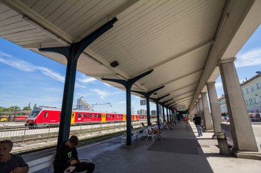 LJUBLJANA, SLOVENIA - JUNE 15, 2021: passengers waiting for the departure of trains on a platform of Ljubljana Zelezniska Postaja, the main train station of the city and a major Slovenian railways hub