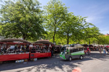 LJUBLJANA, SLOVENIA - 15 Haziran 2021: Elektrikli bir mekikteki seçici bulanıklık, Ljubljana merkez pazarında, yaya ortamında elektrikle çalışan bir minibüs