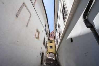 Slovenya 'nın tarihi merkezi Skofja Loka' da orta çağdan kalma bir bölgede tarihi bir oyun salonunun üzerinde köprü evi olan boş bir ortaçağ dar sokağı.