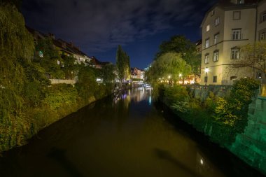 Ljubljanica Nehri 'nin şehir merkezinde yer alan Panorama' da yaz mevsiminde, bir gece boyunca arka planda bir köprü bulunuyor. Slovenya 'nın başkentinin bir sembolü.