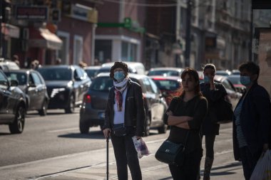BELGRAD, SERBIA - 2 Ekim 2021: Coronavirus Covid 19 krizinde maske takarak Belgrad 'da otobüs durağında bekleyen yaşlı yaşlı bir kadının koltuk değnekleri üzerindeki seçici bulanıklık