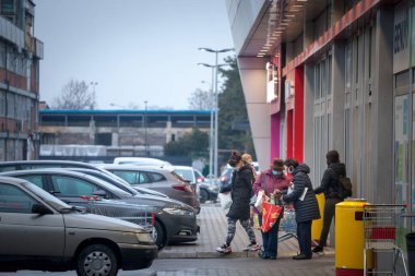 PANCEVO, SERBIA - 21 Mart 2021: Coronavirus Covid 19 krizi sırasında marketin maskesinin önündeki alışveriş poşetlerinin içeriğini kontrol eden iki yaşlı kadının seçici bulanıklığı
