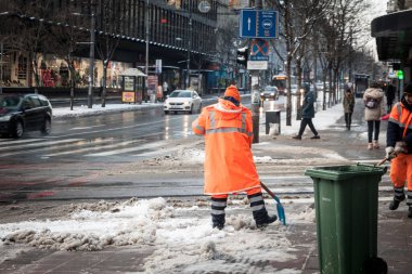 BELGRAD, SERBIA - 22 HAZİRAN 2022: Belgradlı bir şehir çalışanı, soğuk bir kış günü şehirde kar gösterisiyle kar temizleyen flüt ekipmanlı bir şehir çalışanı.