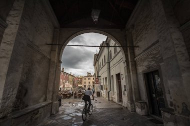 KOPER, SLOVENIA - SEPTEMBER 17, 2021: Presernov trg 'da Fontana Da ponte Fountain, ya da da da da da pontejev vodnjak' ın yanından geçen bisikletli bisikletçi, eski bir İtalyan mimarlık tarzı ortaçağ şehri Koper 'de.