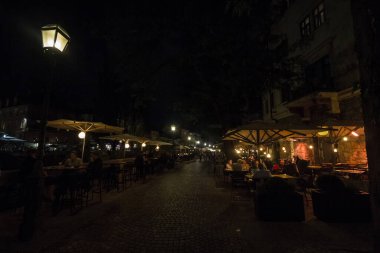 LJUBLJANA, SLOVENIA - SEPTEMBER 18, 2021: Ljubljana 'nın şehir merkezinde, bir kafe restoranının tıklım tıklım dolu avlularında, insanların gece yaşamında, sosyal mesafeye saygı duymadan oturdukları, seçici bulanıklık