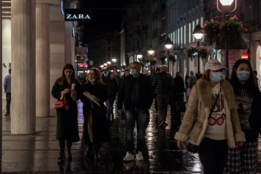 BELGRAD, SERBIA - NOVEMBER 3, 2021: Coronavirus Covid 19 krizinde yüz maskesi koruyucu ekipman takmış bir aile, baba, anne ve kızları seçici bulanıklık