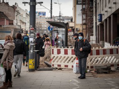 BELGRAD, SERBIA - 20 Kasım 2021: Coronavirus covid 19 sağlık krizi sırasında Belgrad otobüs durağında ulaşımı bekleyen solunum maskesi takan yaşlı adam