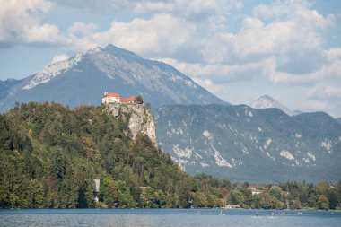 BLED, SLOVENIA - 11 SEPTEMBER 2021: İnsanlar Bled kalesinin önünde ayakta kürek çekiyorlar, ya da Blejsko Jezero 'da Blejsko Hrad yapıyorlar,