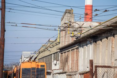 Elektrik direği ve tramvayın kablo hattına, tepe kablosuna ya da Worskhop deposundaki ihmal edilmiş endüstriyel bir arkaplanda yer alan kateteriye bağlı pantograf..