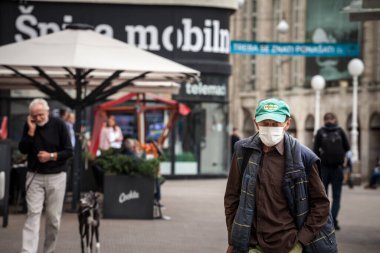 ZAGREB, CROATIA - 19 Eylül 2021: Coronavirus covid 19 sağlık krizi sırasında Hırvatistan 'ın Zagreb kentinde yürüyen ve solunum maskesi takan yaşlı bir adam