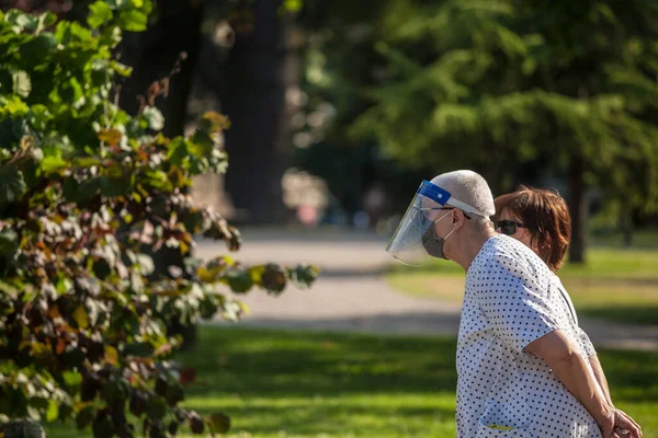 BELGRAD, SERBIA - 26 Haziran 2021: Coronavirus covid 19 sağlık krizi sırasında Belgrad caddesinde yürüyen, solunum maskesi takan ve yüz maskesi takan yaşlı adam