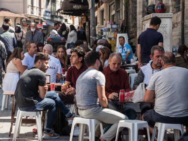 İSTANBUL, TURKEY - 21 Mayıs 2022: Türkiye 'de İstanbul' un Avrupa yakasında kalabalık fast food ve kafe teraslarında oturan Türkler hakkında seçici bulanıklık