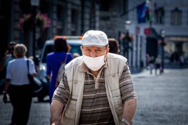 LJUBLJANA, SLOVENIA - SEPTEMBER 15, 2021: Yaşlı yaşlı adamı seçici bulanıklık, tek başına, maske takarak yürümek, Coronavirus covid 19 krizi sırasında Ljubljana caddesinde uyanmak