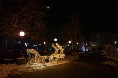 PANCEVO, SERBIA - 16 HAZİRAN 2022: Pancevo 'nun ana meydanının Noel süslemelerinde seçici bulanıklık, geceleri, karın altında, kışın, yılbaşı ve Noel için aydınlatılmış