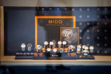 LJUBLJANA, SLOVENIA - SEPTEMBER 15, 2021: Mido logo on a jewelry boutique with watches of the Brand. Mido is a Swiss watchmaker famous for chronographs and watches part of Swatch clipart