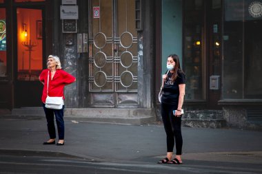BELGRAD, SERBIA - 12 Temmuz 2022: Coronavirus Covid 19 krizinde maske koruyucu ekipman takmış yaşlı bir kadın Belgrad bulvarında karşıdan karşıya geçmek için seçici bulanıklık