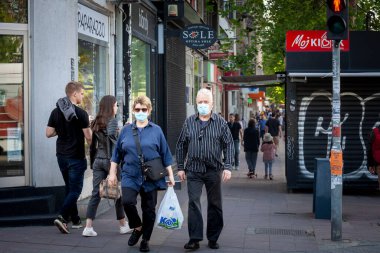 BELGRADE, MAY 15, 2021: Selective blur on Old senior man and woman, couple, wearing a facemask, waking in street of Belgrade in summer during  coronavirus covid 19 health crisis